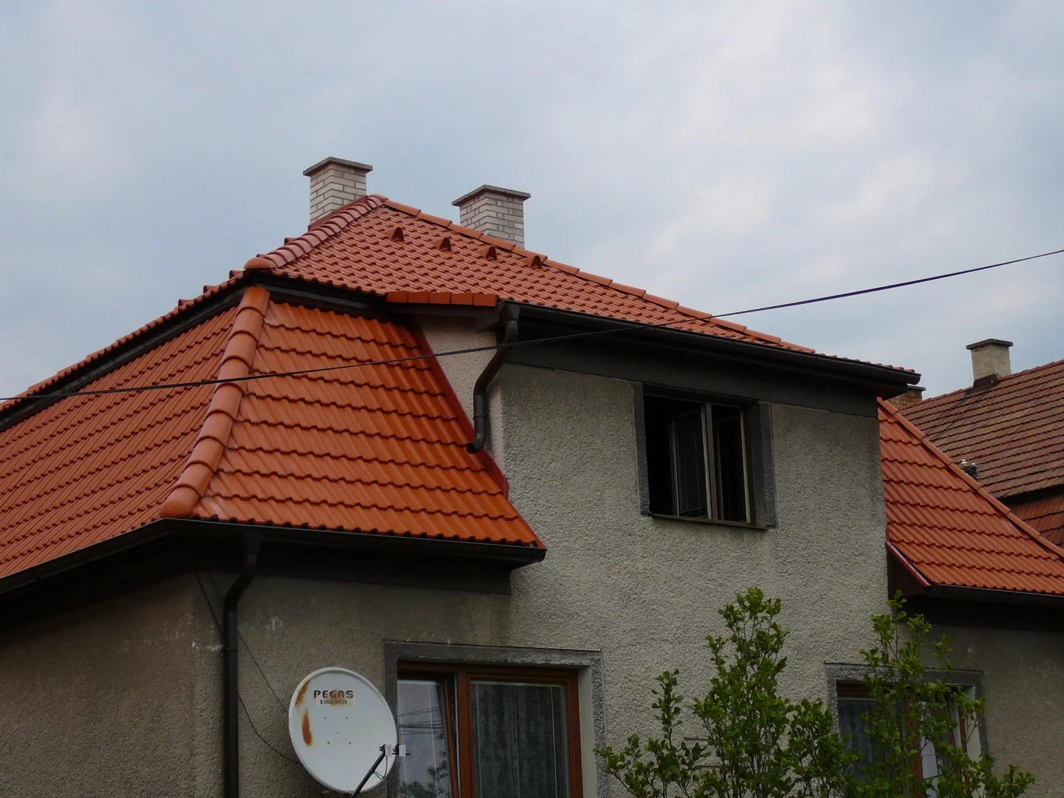 Rodinný dom s červenou škridlovou strechou a valbami