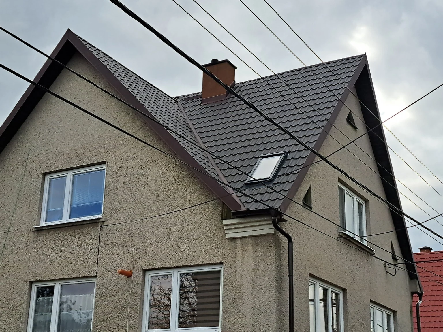 Antracitová strecha rodinného domu s vikiermi a strešným oknom